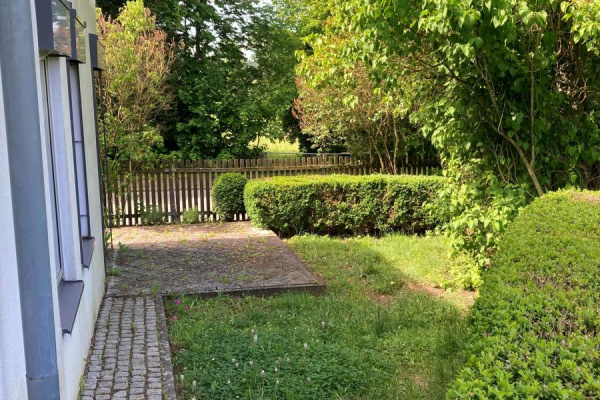 Eine umzäunte Terrasse, die eher an einen kleinen Garten erinnert....