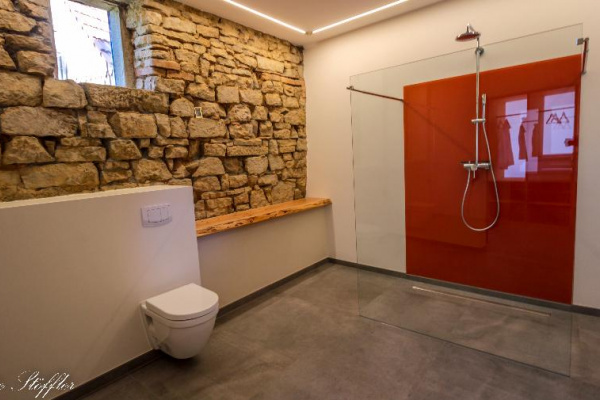 Traum-Bad mit alter, beleuchteter Steinwand